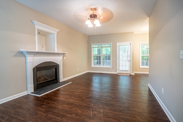 empty,%20unfurnished%20living%20room%20with%20dark%20wood%20flooring%20and%20a%20fireplace